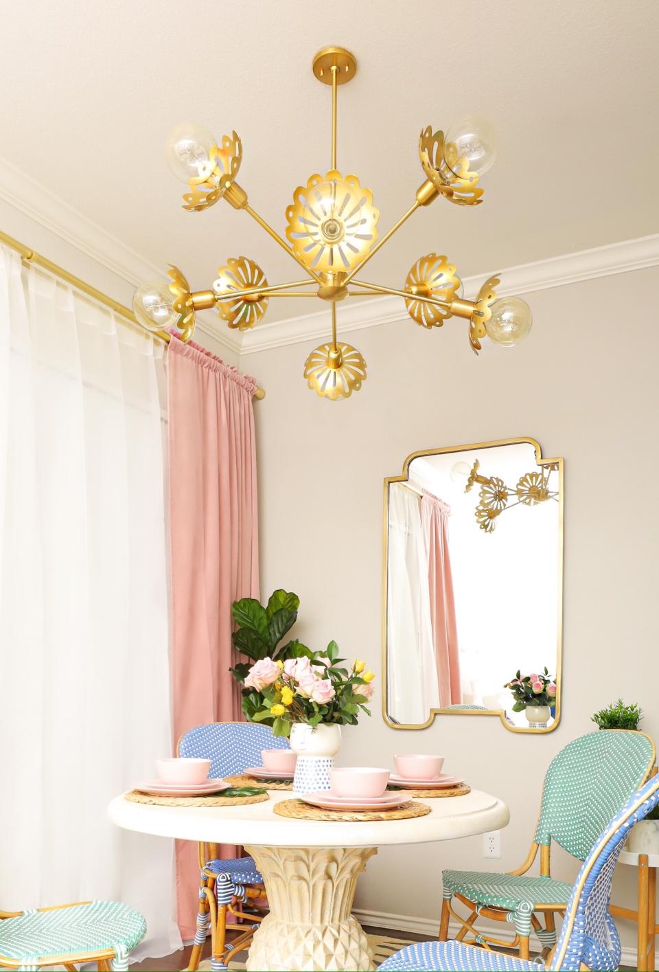 This photo provided by Hudson Valley Lighting Group shows the Alyssa Chandelier by Mitzi. In lighting fixtures, wallpapers, bedding and wall art, floral design is having a big year in 2020. There's also a renewed interest in flower arranging and floral-inspired table settings. (Fred Moser/Kelly Golightly/Mitzi via AP)