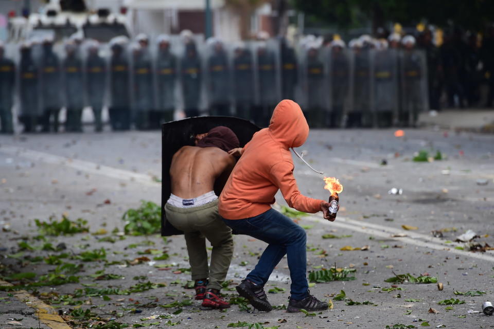 An anti-government activist prepares to throw a Molotov cocktail at members of the National Guard during a 48-hour general strike called by the opposition on July 24.