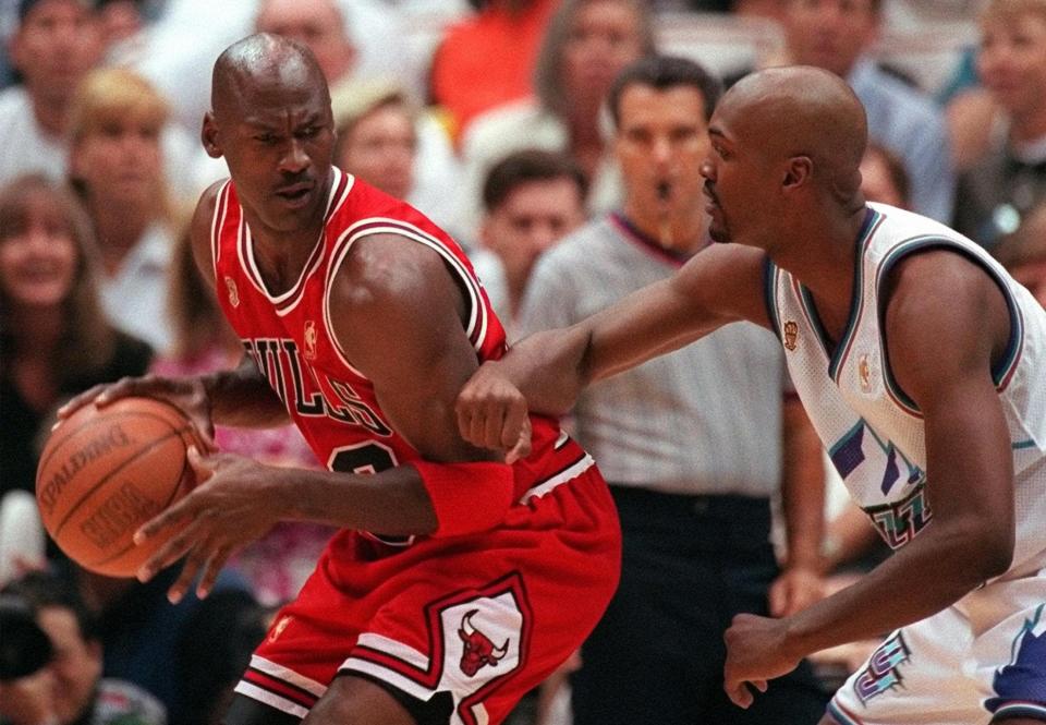 Chicago Bulls' Michael Jordan scowls over his shoulder as he is guarded closely by Utah Jazz's Bryon Russell during the first quarter of Game 4 in the NBA Finals on Sunday, June 8, 1997, in Salt Lake City. (AP Photo/Douglas C. Pizac)