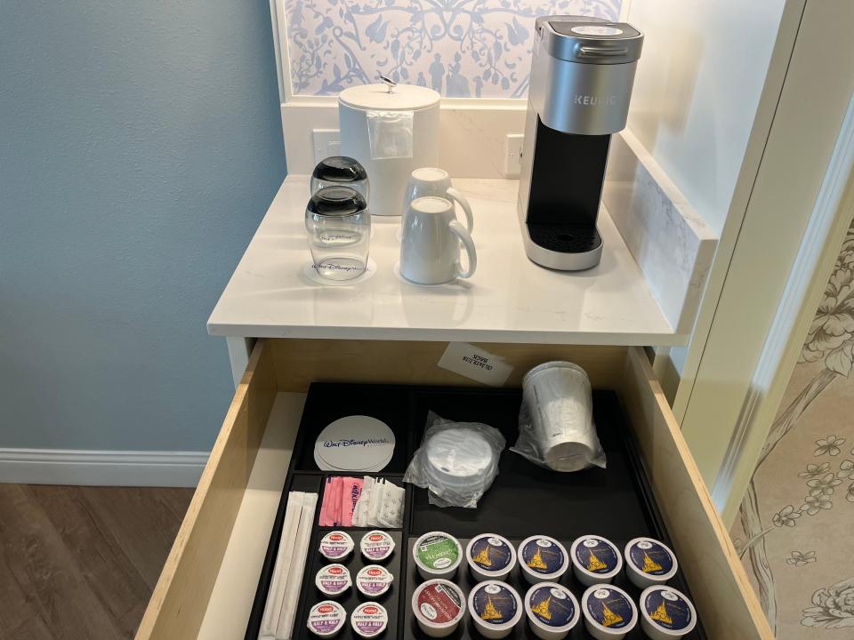 coffee station with a coffee maker, cups, and coffee pods in a room inside the grand floridian resort