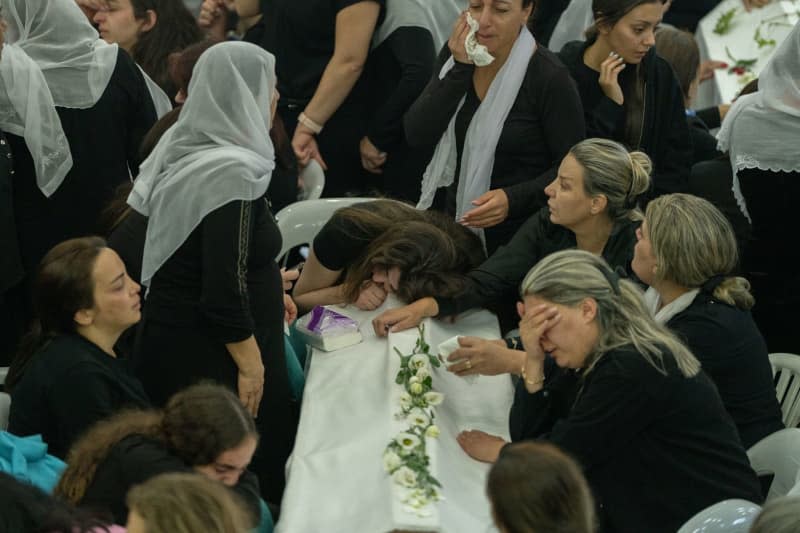 A woman mourns during the funeral of their relatives at the Druze town of Majdal Shams.  Twelve children and young people were killed when a rocket fired by the Iran-backed Hezbollah militia in southern Lebanon hit a football field in the Israeli-occupied Golan Heights. Ilia Yefimovich/dpa