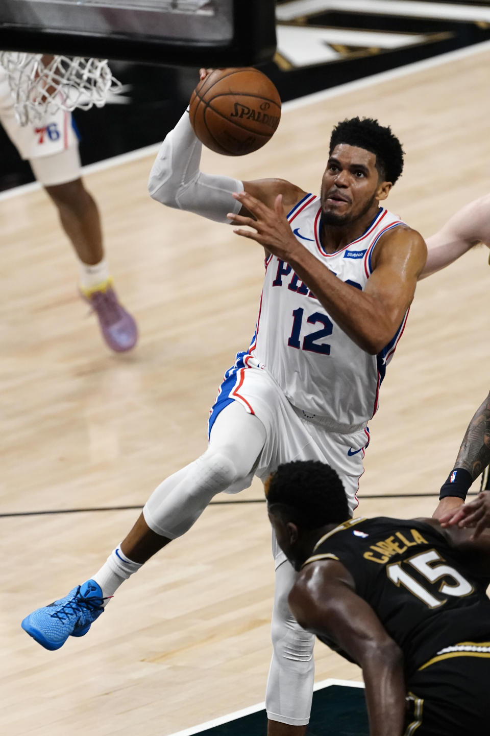 CORRECTS TO 76ERS' TOBIAS HARRIS NOT GARY CLARK - Philadelphia 76ers' Tobias Harris (12) drives to the basket as Atlanta Hawks center Clint Capela (15) defends during the first half of Game 6 of an NBA basketball Eastern Conference semifinal series Friday, June 18, 2021, in Atlanta. (AP Photo/John Bazemore)