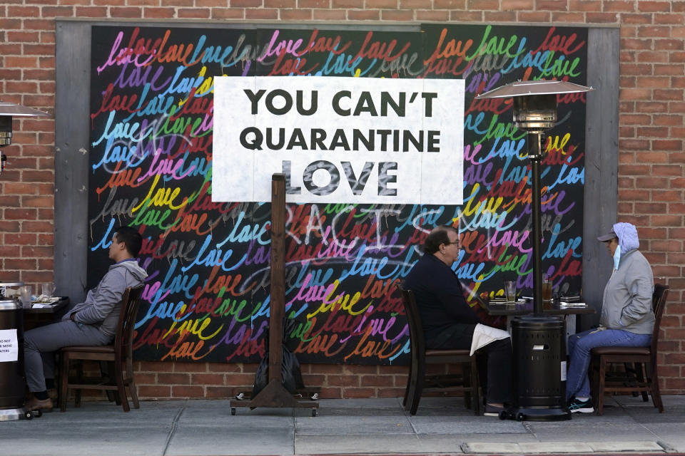 FILE - In this Nov. 23, 2020, file photo a COVID-19-themed mural reads "You Can't Quarantine Love," outside of a restaurant in Santa Monica, Calif. Los Angeles County has announced a new stay-home order as coronavirus cases surge out of control in the nation's most populous county. The three-3 week order take effect Monday, Nov. 30, 2020. The order advises residents to stay home "as much as possible" and to wear a face covering when they go out. (AP Photo/Marcio Jose Sanchez, File)