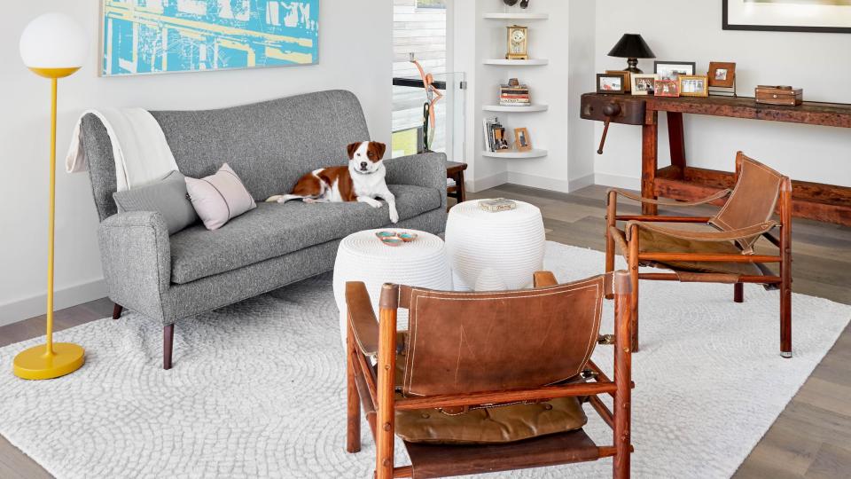 a living room with a couch and leather arm chairs