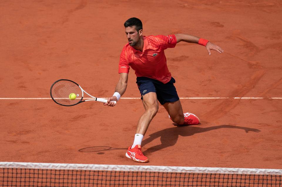 Novak Djokovic returns a shot during his semifinal match against Carlos Alcaraz during the French Open semifinals.