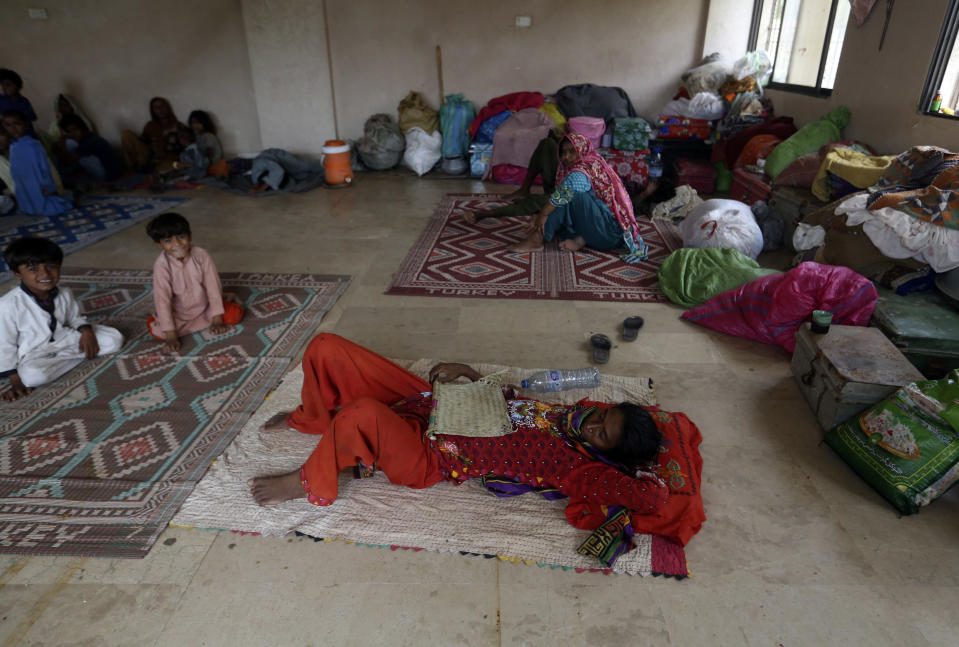 Displaced Pakistani families take refuge in a government college building after fleeing their flood-hit homes, in Karachi, Pakistan, Monday, Aug. 29, 2022. International aid was reaching Pakistan on Monday, as the military and volunteers desperately tried to evacuate many thousands stranded by widespread flooding driven by "monster monsoons" that have claimed more than 1,000 lives this summer. (AP Photo/Fareed Khan)