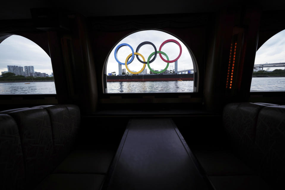 FILE - In this April 12, 2021, file photo, the Olympic rings floating in the water in the Odaiba section are seen from a window of a water bus, in Tokyo. Public sentiment in Japan has been generally opposed to holding the Tokyo Olympics and Paralympics. This is partly based of fears the coronavirus will spike as almost 100,000 people — athletes and others — enter for both events.(AP Photo/Eugene Hoshiko, File)