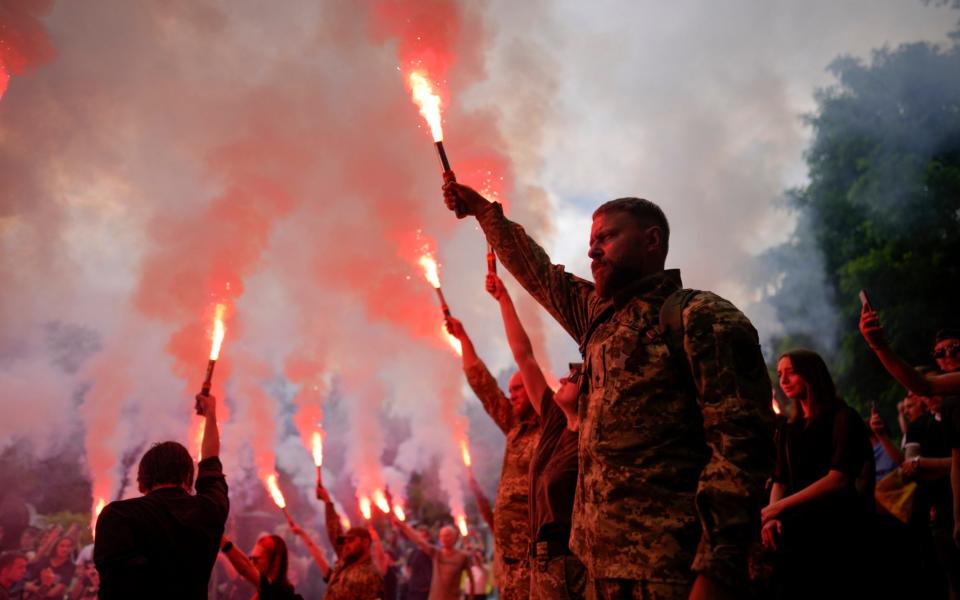 Soldiers hold flares as they attend the funeral of activist and soldier Roman Ratushnyi in Kyiv, Ukraine, Saturday, June 18, 2022.  - AP Photo/Natacha Pisarenko