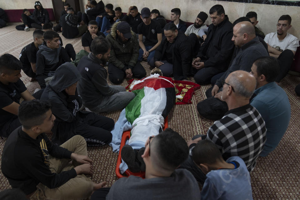 Mourners take the last look at the body of Palestinian Mohammad Shahmawi, 22, at a mosque in the West Bank refugee camp of al-Faraa, Friday, April 12, 2024. Two Palestinians were killed early Friday in confrontations with Israeli forces in the Israeli-occupied West Bank, Palestinian medics and the Israeli military said. The Islamic militant group Hamas said one of those killed was a local commander. (AP Photo/Nasser Nasser)