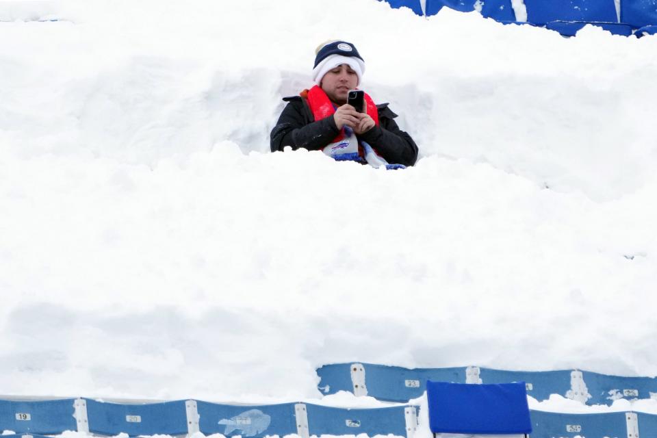 A fan sits in the snow at Highmark Stadium in Orchard Park, New York during the AFC wild-card game between the Pittsburgh Steelers and the Buffalo Bills on Monday.