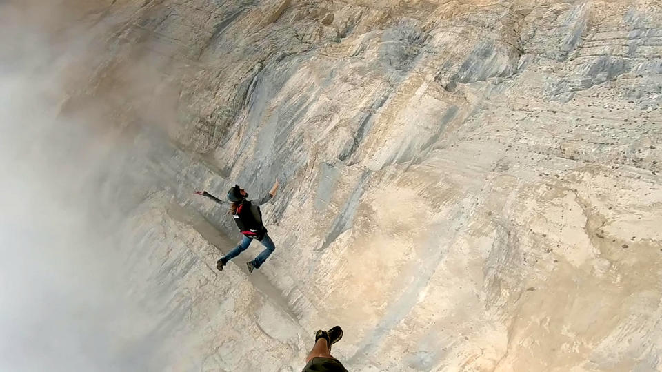 These friends filmed themselves freefalling backwards from a cliff - while holding hands. Josephine Eve, 28, and Niclas Strohmeier, 23, performed the stunt at the BASE jumping hotspot of Monte Brento, Italy. They fall backwards into the dense mist below before separating in the air and landing safely.