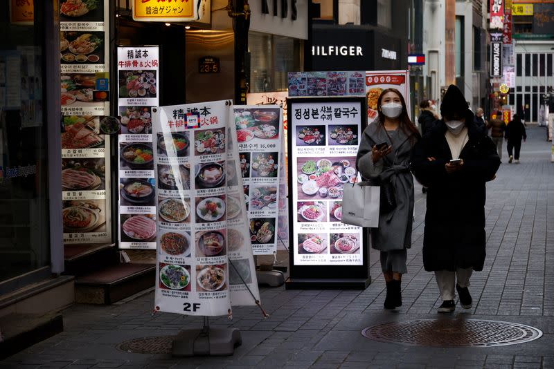 Women walk in an empty shopping district amid the coronavirus disease (COVID-19) pandemic in Seoul