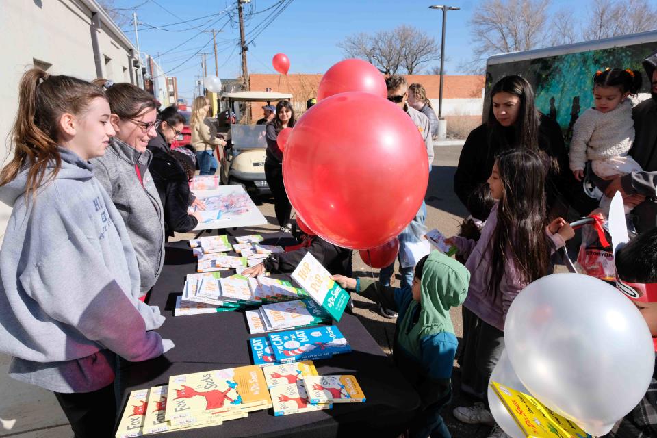 A young boy chooses a Dr. Seuss book at Storybridge's “Cat in the Hat March” celebrating Read Across America in Amarillo.