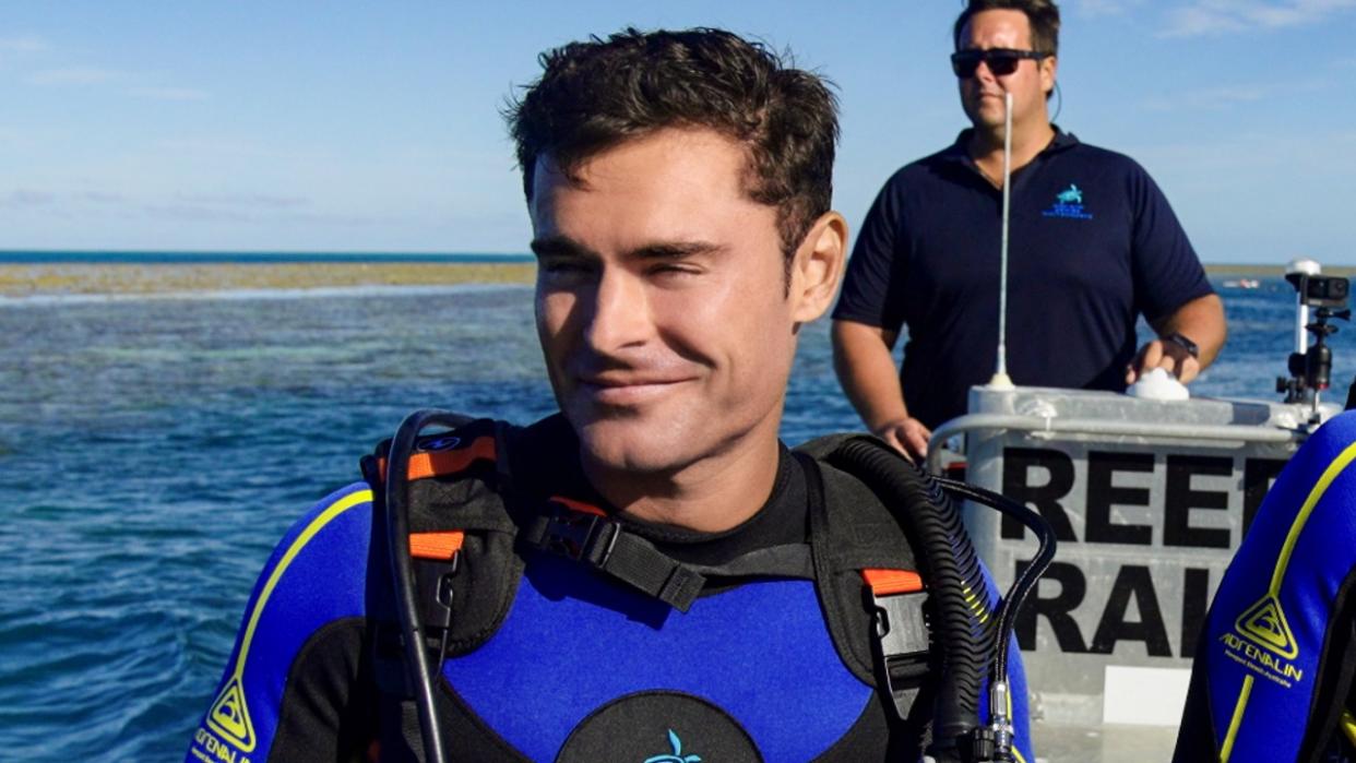  Zac Efron on a boat in a wetsuit in Down to Earth with Zac Efron 