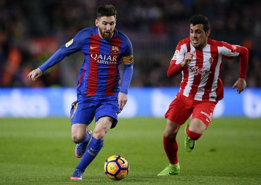 FC Barcelona's Lionel Messi, left, duels for the ball against Sporting Gijon's Carlos Castro during the Spanish La Liga soccer match between FC Barcelona and Sporting Gijon at the Camp Nou stadium in Barcelona, Spain, Wednesday, March 1, 2017. (AP Photo/Manu Fernandez)