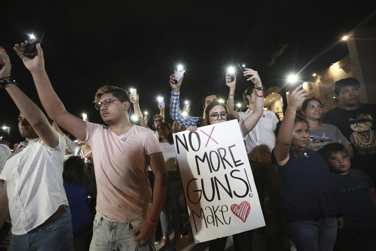 People gather in Juarez, Mexico, Saturday, Aug. 3, 2019, in a vigil for the 3 Mexican nationals who were killed in an El Paso shopping-complex shooting. Twenty people were killed and more than two dozen injured in a shooting Saturday in a busy shopping area in the Texas border town of El Paso, the state’s governor said. (AP Photo/Christian Chavez)