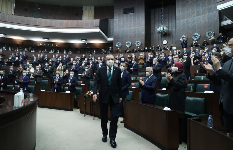 Turkish President Tayyip Erdogan leaves his seat to address members of parliament from his ruling AK Party in Ankara