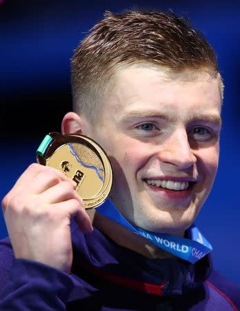 Swimming – 17th FINA World Aquatics Championships – Men's 100m Breaststroke awarding ceremony – Budapest, Hungary – July 24, 2017 – Adam Peaty of Britain (gold) poses with the medal. REUTERS/Michael Dalder