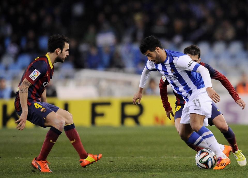 Real Sociedad's Carlos Vela of Mexico, right, tries to control the ball in front FC Barcerlona's Francesc Fabregas, during their Spanish Copa del Rey semifinal second leg soccer match, at Anoeta stadium, in San Sebastian northern Spain, Wednesday, Feb. 12, 2014. (AP Photo/Alvaro Barrientos)