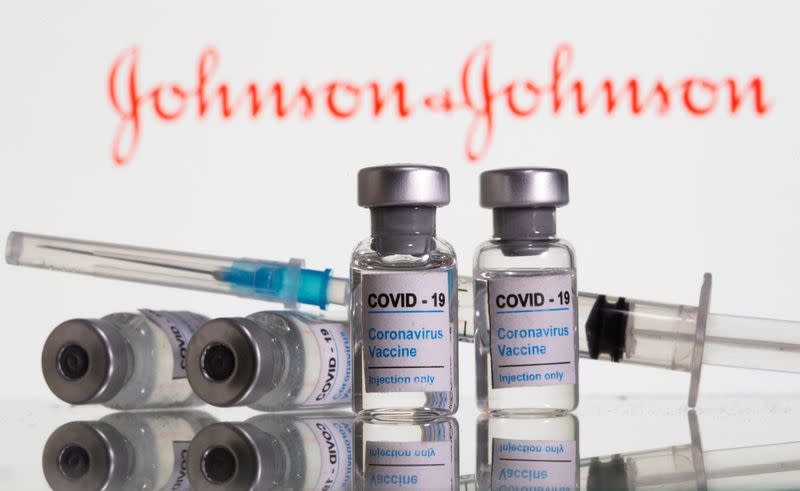 FILE PHOTO: Vials labelled "COVID-19 Coronavirus Vaccine" and sryinge are seen in front of displayed J&J logo in this illustration