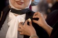 A new judge receives a judges pin during a swearing-in ceremony before Egypt’s State Council, in Cairo, Egypt, Tuesday, Oct. 19, 2021. Ninety eight women have become the first female judges to join the council, one of the country’s main judicial bodies. The swearing-in came months after President Abdel Fattah el-Sissi asked for women to join the State Council and the Public Prosecution, the two judicial bodies that until recently were exclusively male. (AP Photo/Tarek Wajeh)