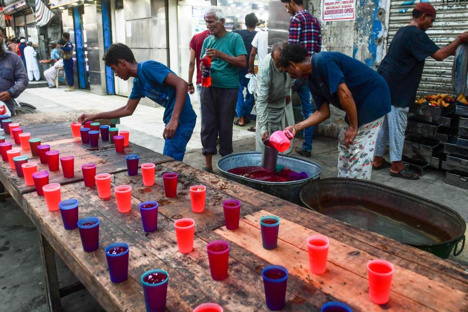 In this picture taken on April 28, 2022, volunteers prepare Rooh Afza drinks, a sweet beverage in Karachi,  Pakistan as the country observes sweltering heat (AFP via Getty Images)