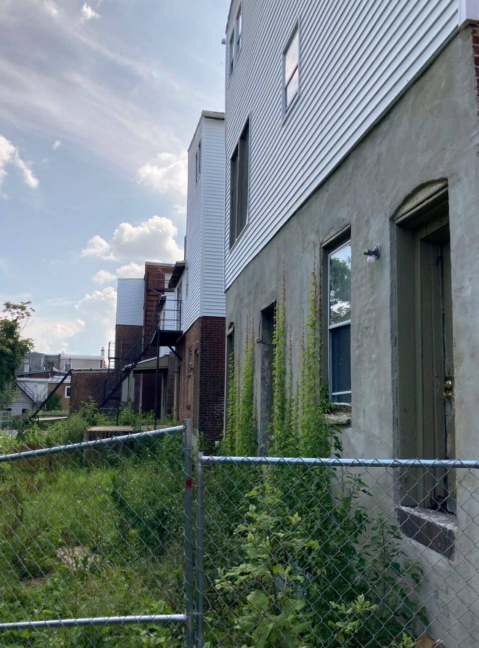 Fencing surrounds the rear of a stretch of condemned apartment residences on the 800 block of N. Adams Street, seen Wednesday, July 5, 2023.