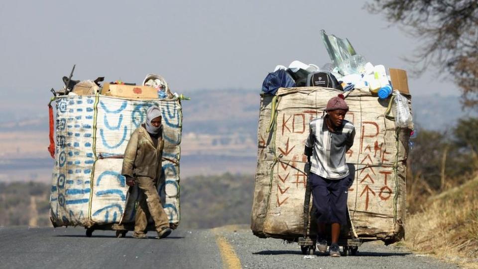 Steven Lesoona and Thabang Pule, waste pickers, pull trolleys loaded with recyclable materials, as they combat unemployment in Naturena, near Johannesburg, South Africa, July 3, 2023