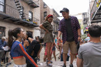 This image released by Warner Bros. Entertainment shows, Melissa Barrera, from left, Daphne Rubin-Vega and director Jon M. Chu on the set of "In the Heights," in theaters an HBO Max on June 11. (Macall Polay/Warner Bros. Entertainment via AP)