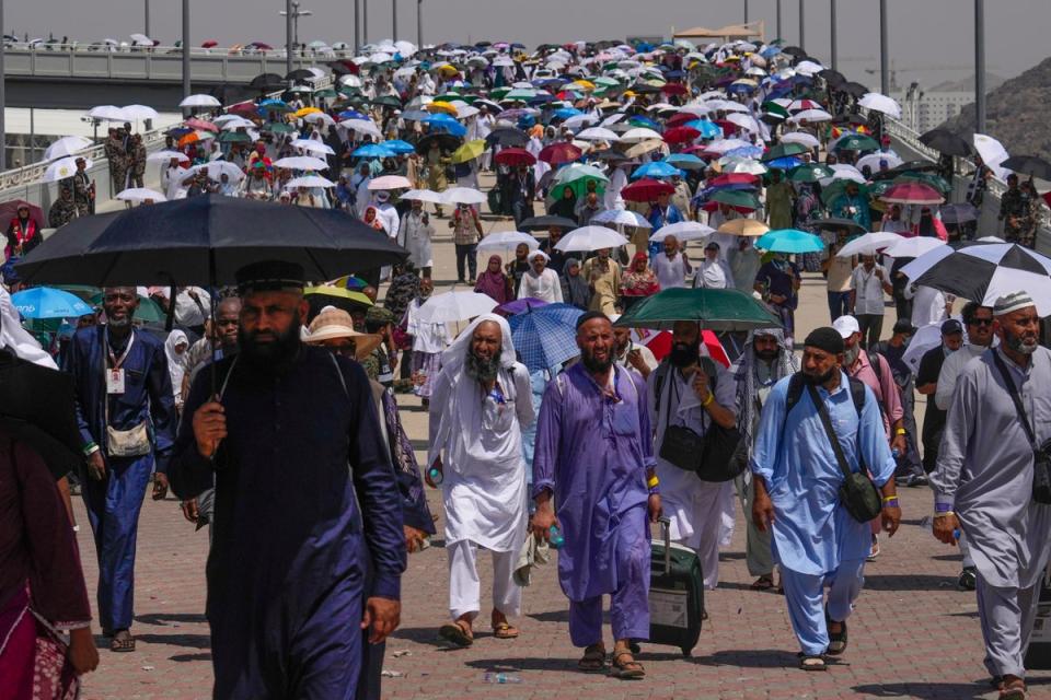 Pilgrims use umbrellas to shield themselves from the sun (AP)