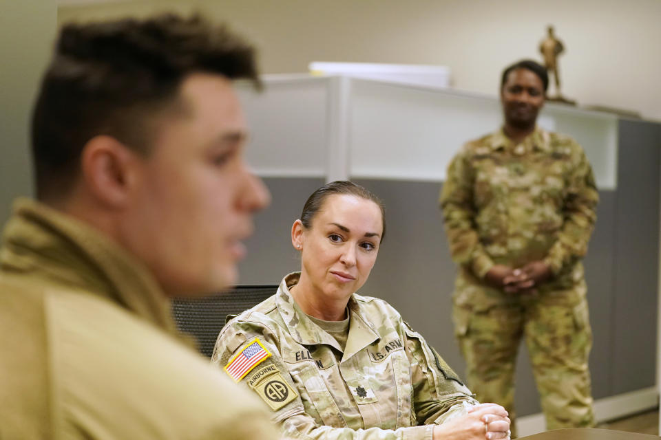 U.S. Army National Guard Recruitment chief Lt. Col. Amber Ellison, center, listens as Sgt. Michael Ray Forbes speaks during an interview with The Associated Press, Thursday, April 21, 2022 in Washington. In March the local guard opened its first proper recruiting office in the city since 2010. The commander, Maj. Gen. Sherrie McCandless, describes the move as a new push for visibility and an emphasis on the guard’s local connections at a time when many residents might be ripe for recruitment. (AP Photo/Mariam Zuhaib)