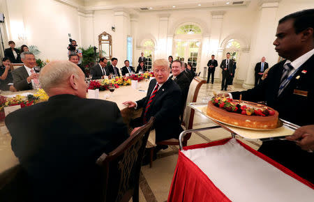 REFILE - CORRECTING GRAMMAR U.S. President Donald Trump is presented with a birthday cake as he attends a lunch with Singapore's Prime Minister Lee Hsien Loong at the Istana in Singapore June 11, 2018. Mandatory credit Ministry of Communications and Information, Singapore/Handout via REUTERS ATTENTION EDITORS - THIS PICTURE WAS PROVIDED BY A THIRD PARTY. NO RESALES. NO ARCHIVE. MANDATORY CREDIT
