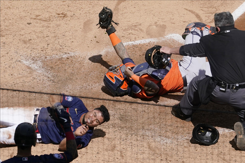 Home plate umpire Manny Gonzalez, right, makes the call after Minnesota Twins' Luis Arraez, left, is tagged out by Houston Astros catcher Martin Maldonado as he attempted to score on a Marwin Gonzalez single in the fifth inning of Game 2 of an American League wild-card baseball series, Wednesday, Sept. 30, 2020, in Minneapolis. Home plate umpire Manny Gonzalez watches to make the call. (AP Photo/Jim Mone)