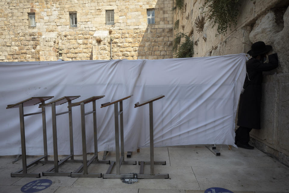 An ultra-Orthodox Jewish man prays ahead of the Jewish new year at the Western Wall, the holiest site where Jews can pray in Jerusalem's old city, Wednesday, Sept. 16, 2020. A raging coronavirus outbreak is casting a shadow over the normally festive Jewish New Year. With health officials recommending a nationwide lockdown, traditional family gatherings will be muted, synagogue prayers will be limited to small groups and roads will be empty. (AP Photo/Sebastian Scheiner)