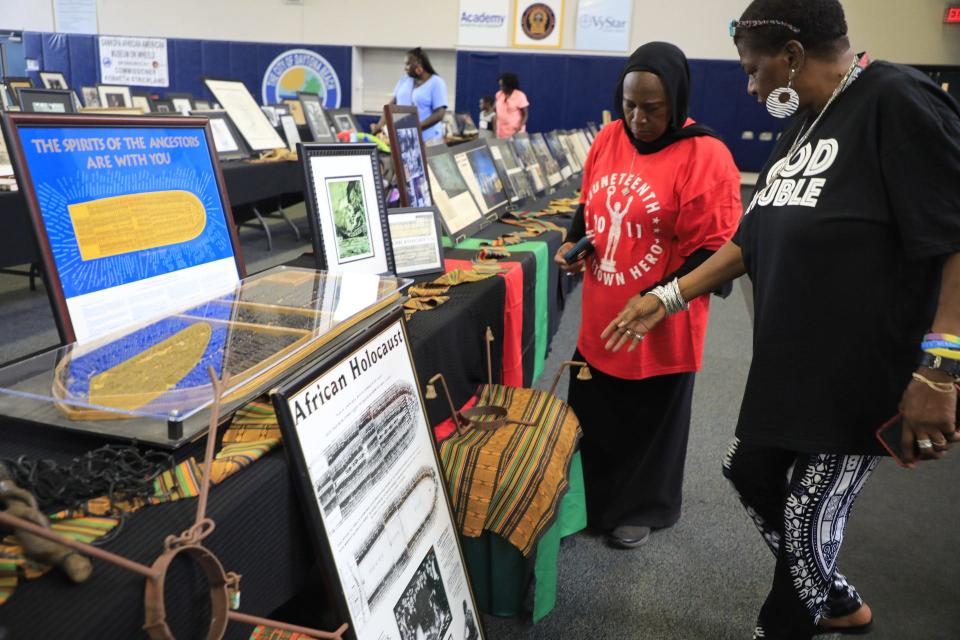 Angela Jennings, at right, tells Linda McGee, longtime Daytona Beach Juneteenth Festival Committee chairwoman, about neck shackles, also known as the "runaway collar," at a Juneteenth celebration in Daytona Beach. Jennings brought her Sankofa African American Museum on Wheels to the city's Juneteenth event.