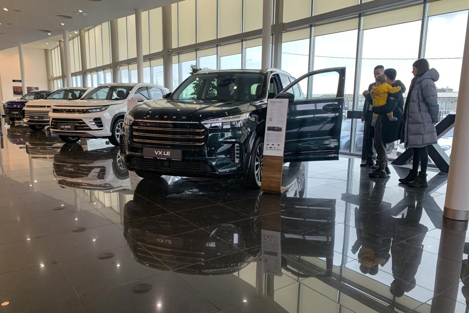 People look at vehicles at a car dealerships store, in St. Petersburg, Russia, Saturday, March 9, 2024. China replaced the European Union as Russia's main trade partner, and Chinese vehicles swiftly took over half the car market last year. (AP Photo)