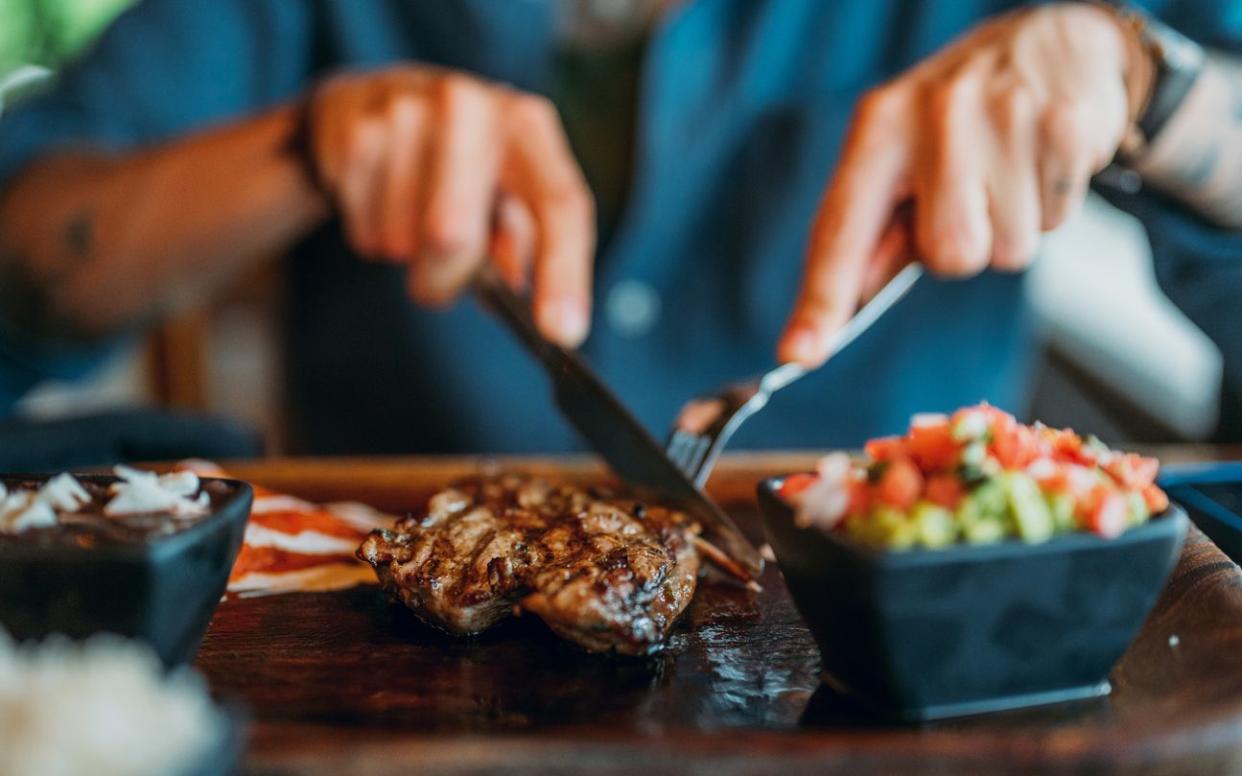 Close-up of someone cutting into a nice steak dinner.