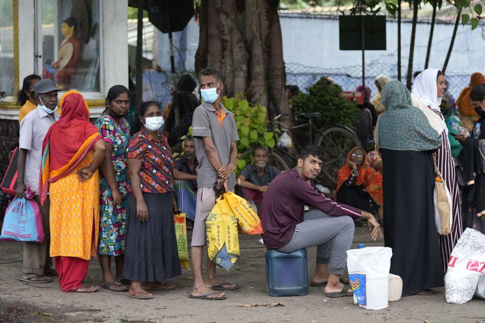 People wait in a fuel station to buy kerosene oil for cooking in Colombo, Sri Lanka, Wednesday, May 18, 2022. Sri Lanka is near bankruptcy having announced that it is suspending upto $ 7 billion foreign loans due to be repaid this year because of a foreign currency crisis. It has led to limited imports with no gasoline in filling stations. Other fuel, cooking gas, medicine and foods are in short supply forcing people to stay in long lines to buy the limited stocks. (AP Photo/Eranga Jayawardena)