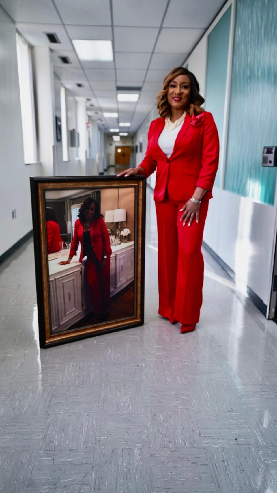 Interim superintendent Toni Williams, with a large photo of her mother. Williams is wearing the same suit that her mother was wearing in the picture.