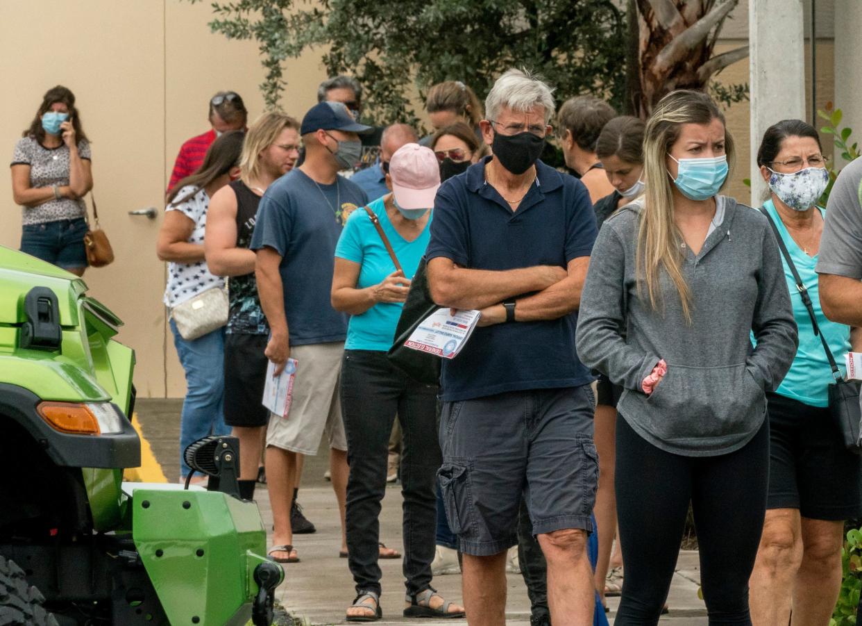 Voters stand in line to cast their votes at an early voting site at the Wellington Branch Library in Wellington, Florida on October 21, 2020. (GREG LOVETT / THE PALM BEACH POST)