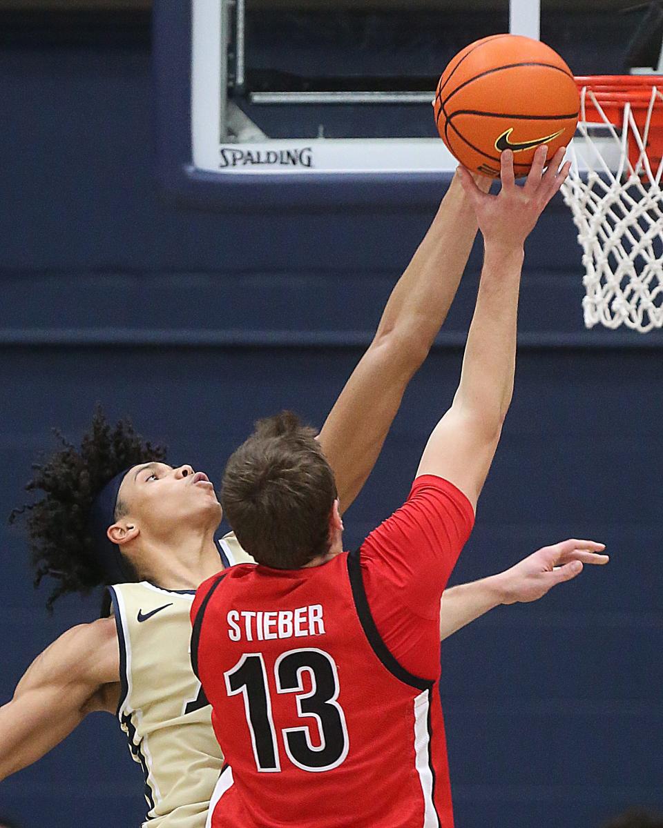 University of Akron's Enrique Freeman swats a shot at the rim in overtime by Gardner-Webb's Lucas Stieber on Thursday in Akron.