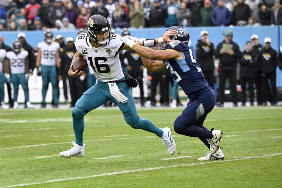 Jacksonville Jaguars quarterback Trevor Lawrence (16) slips past Tennessee Titans linebacker Dylan Cole during the second half of an NFL football game Sunday, Dec. 11, 2022, in Nashville, Tenn. (AP Photo/Mark Zaleski)