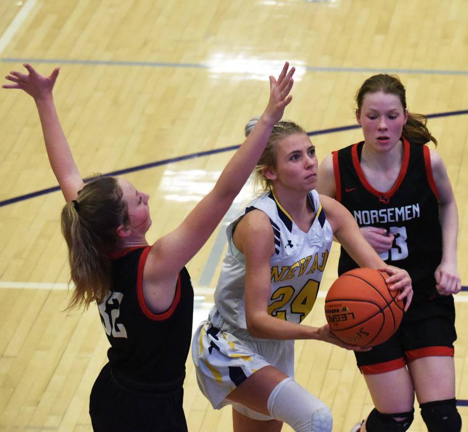 Nevada's Hallee Schadt splits Roland-Story's Kate Berggren (left) and Alynn Solberg during a drive to the basket in the second half of the Cubs' 32-28 loss to the Norse Dec. 6 at the Nevada High School Field House.