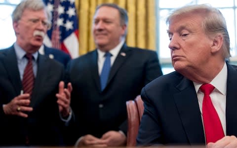From left, National Security Adviser John Bolton, accompanied by Secretary of State Mike Pompeo, and President Donald Trump - Credit: AP