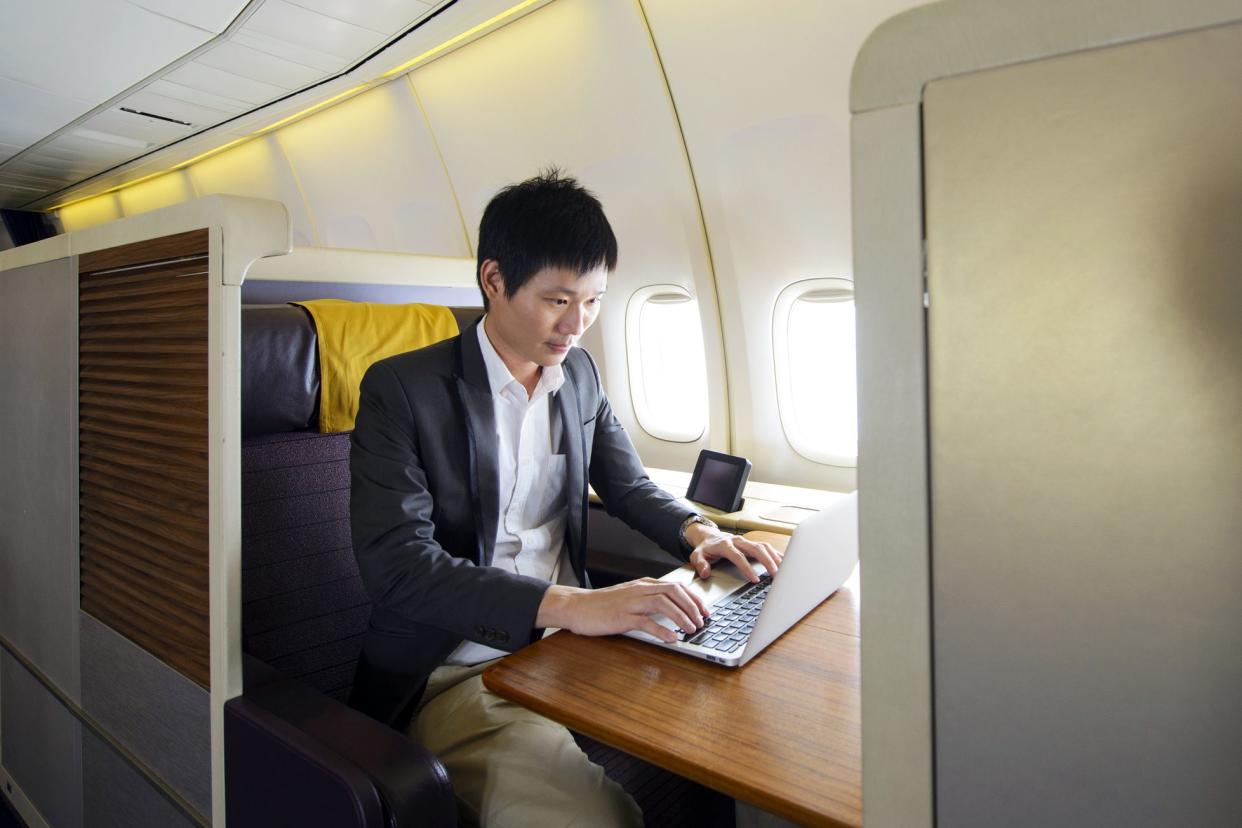 man using laptop in first class