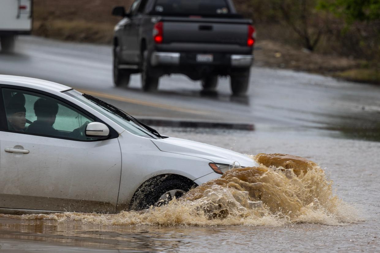Motorists maneuver a flooded roadway on March 10, 2023 in Strathmore, California.