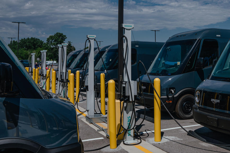 Amazon delivery electric vans (EV), built by Rivian Automotive, at charging stations parked outside the Amazon Logistics warehouse in Chicago, Illinois on Thursday, July 21, 2022. Amazon Inc. is starting delivery of packages to US customers using the first of as many as 100,000 electric vans built by Rivian Automotive Inc., which aims to hand over thousands of the vehicles this year.<span class="copyright">JAMIE KELTER DAVIS—BLOOMBERG/GETTY IMAGES</span>