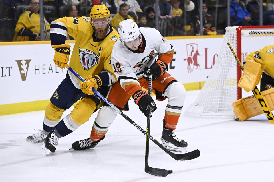 Nashville Predators defenseman Mattias Ekholm (14) and Anaheim Ducks right wing Troy Terry (19) compete for the puck during the first period of an NHL hockey game Tuesday, Nov. 29, 2022, in Nashville, Tenn. (AP Photo/Mark Zaleski)