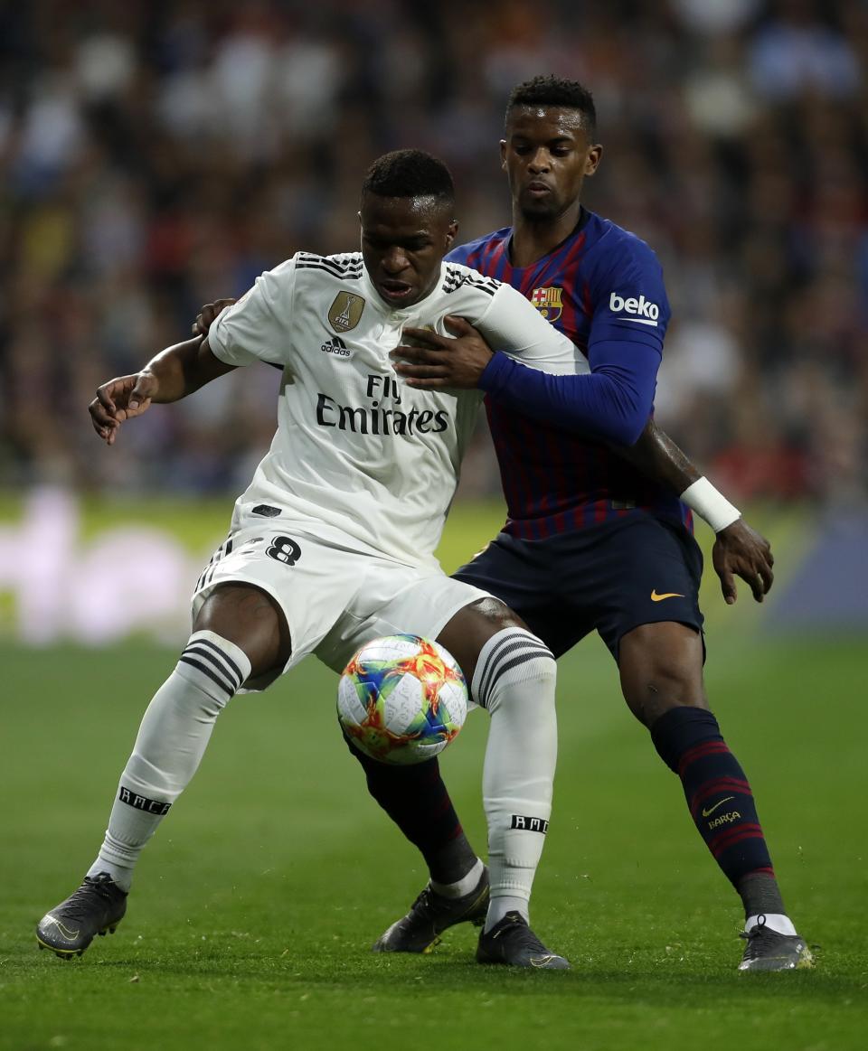 Real forward Vinicius Junior, left, and Barcelona defender Nelson Semedo challenge for the ball during the Copa del Rey semifinal second leg soccer match between Real Madrid and FC Barcelona at the Bernabeu stadium in Madrid, Wednesday, Feb. 27, 2019. (AP Photo/Manu Fernandez)