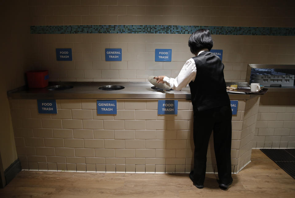 In this March 26, 2019, photo, an employee scrapes food from her plate in the employee dining area at the Palazzo casino-resort in Las Vegas. The Venetian and Palazzo casino-resorts, which are operated by Las Vegas Sands, send their food scraps to the Las Vegas Livestock pig farm 25 miles north of the Strip. (AP Photo/John Locher)